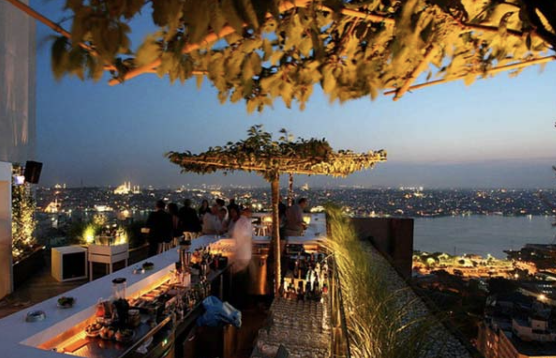 Rooftop bar overlooking Istanbul at sunset.