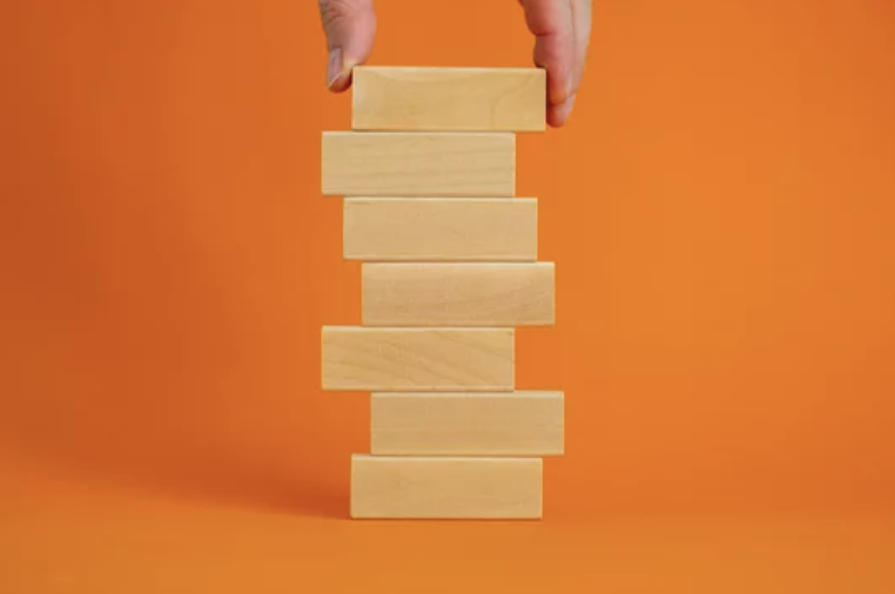 A hand stacking Jenga blocks