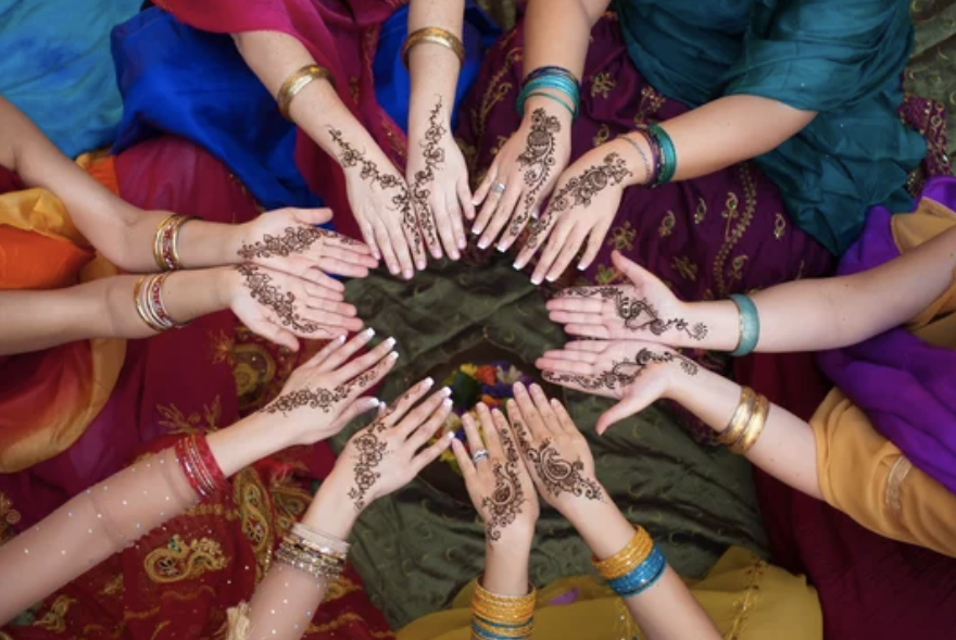 Women's hands with Henna tattoos forming a circle.
